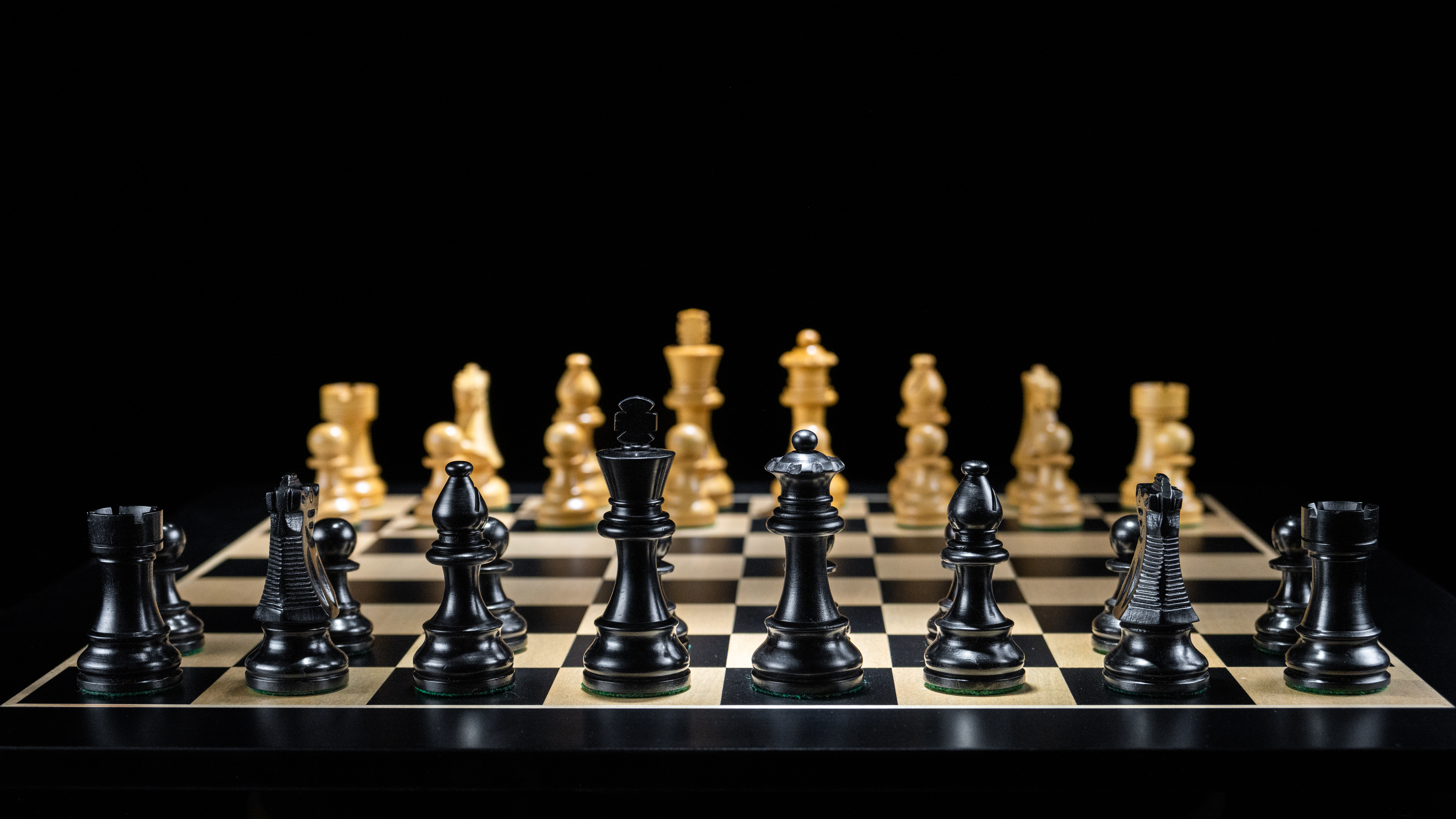 Chess pieces seen from above under dramatic light — competitive intelligence is about seeing the whole board