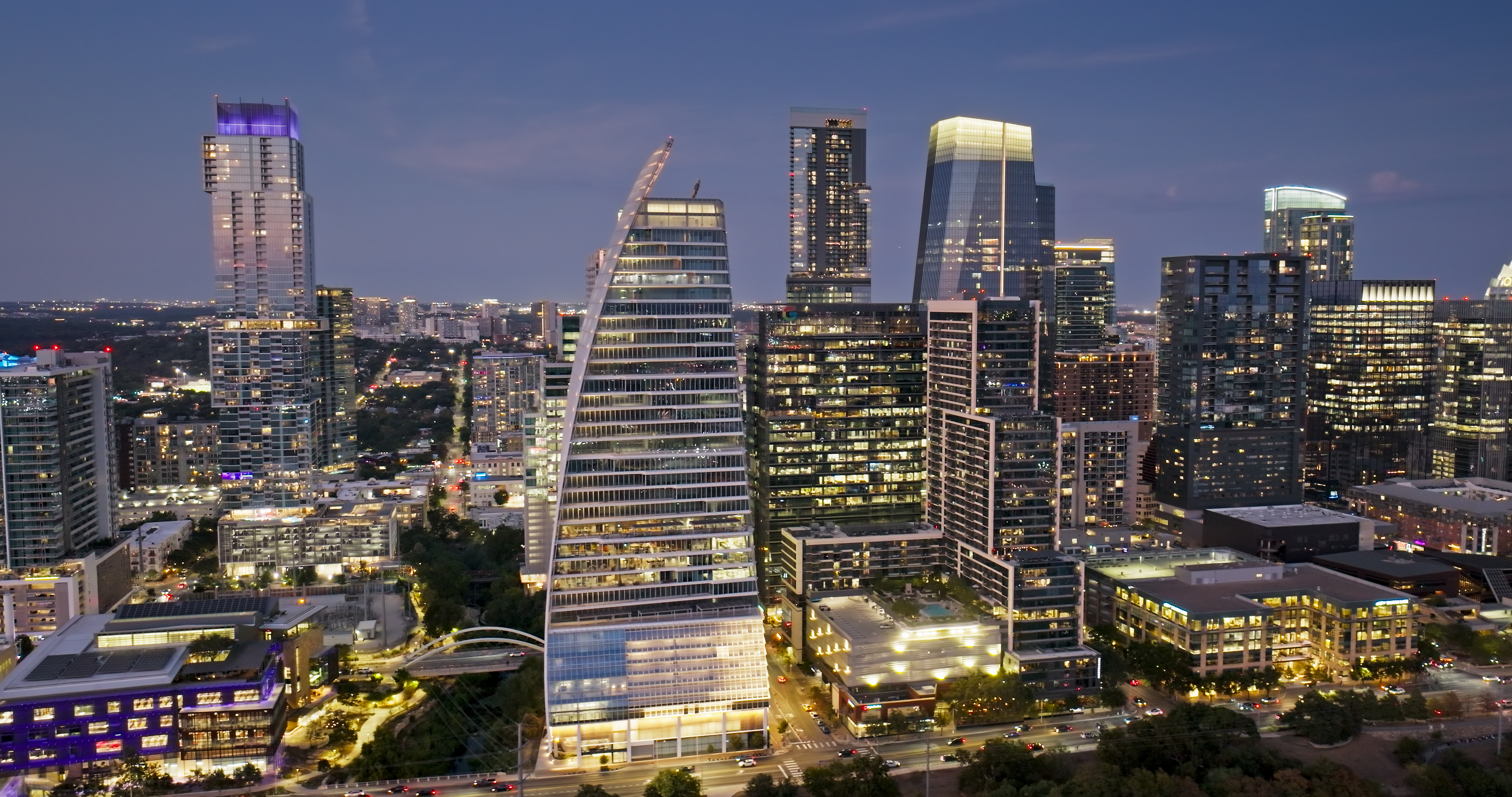 Downtown skyline at dusk seen from the air — the financial brands AI trusts most are the ones with the tallest public profiles