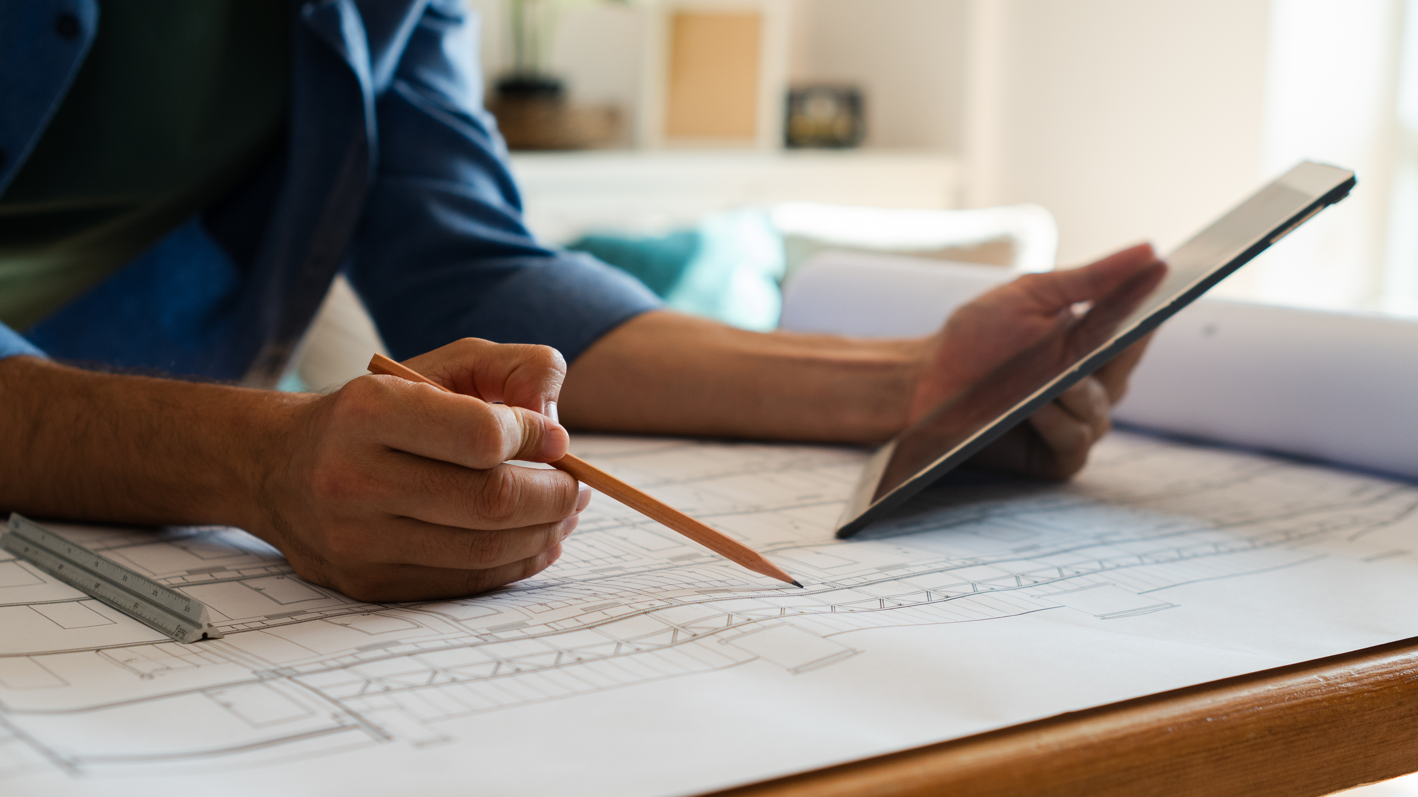 Hands over blueprints on a drafting table — in professional services, reputation is the product